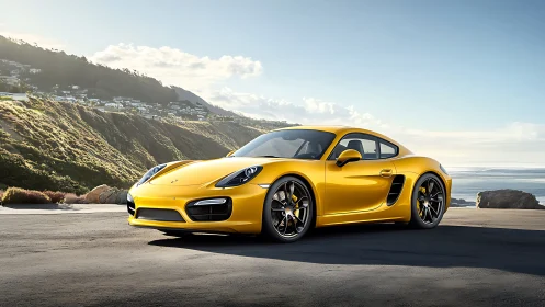 Golden sports coupe gleams beside a dramatic coastal cliff road