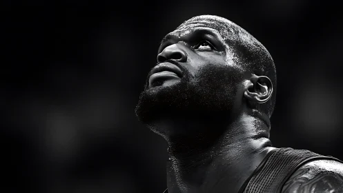 Sweat-lit titan gazes skyward in stark arena chiaroscuro.