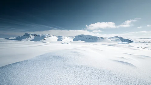 Snow-covered mountain plateau under clear winter sky.