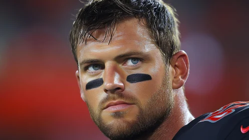 Focused football player under bright stadium lights.