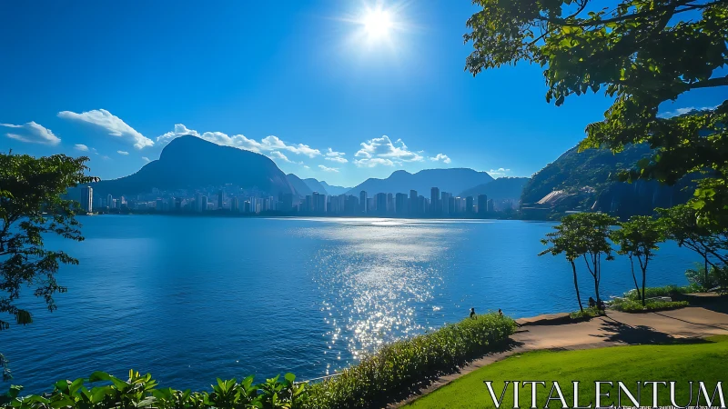 Sunlit urban bay with mountains, skyline, and waterfront park.