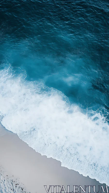 Ocean waves break onto light sand shoreline from above