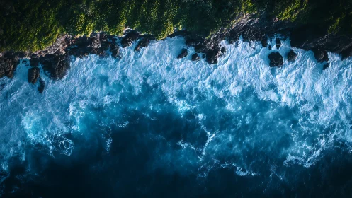 Ocean waves welcoming a lush cliffside in calming embrace.