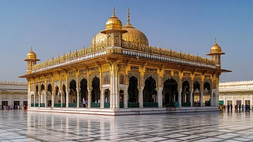 Gilded courtyard shrine shimmering under a cloudless sky.