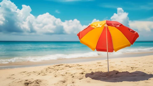 Bright beach umbrella on sunlit shore under blue sky.
