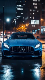 Front view of wet blue Mercedes sports car at night.