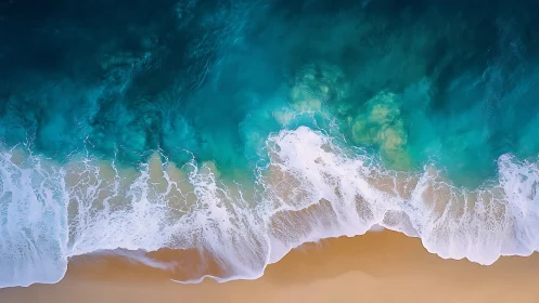 Overhead view of turquoise ocean surf on sandy shoreline.