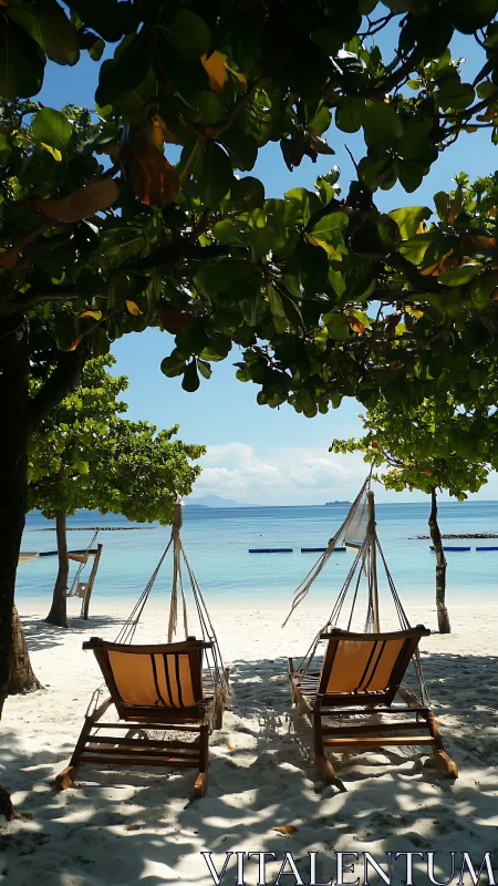 Two hammock chairs on shaded tropical beach shoreline.