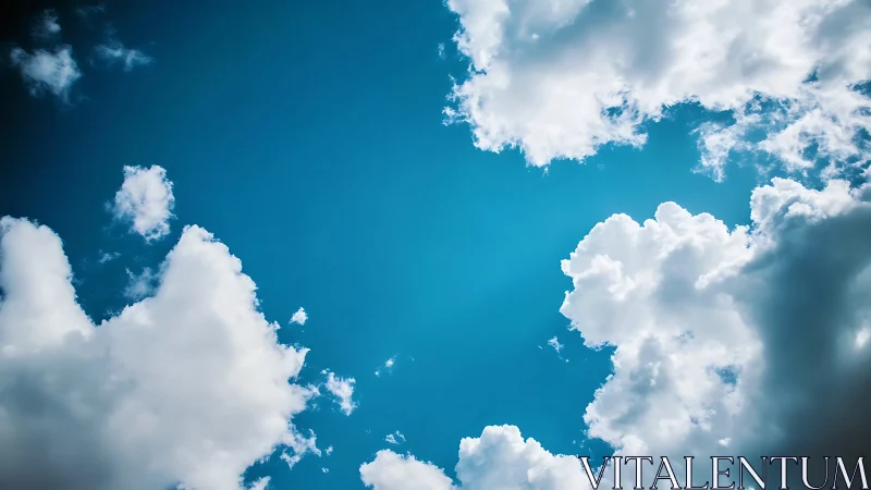Bright blue sky with fluffy white clouds in natural daylight.