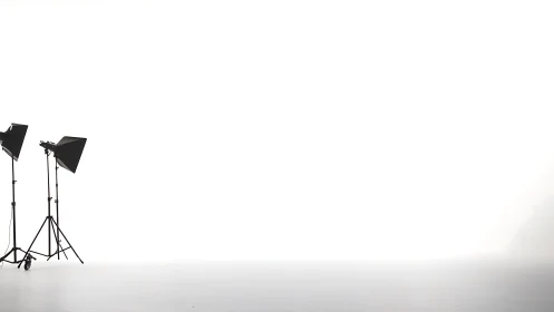 Minimalist studio lighting rig on high-key white cyclorama.