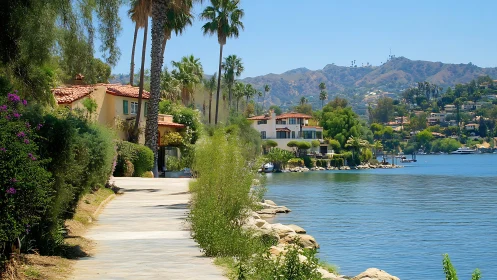 Lakeside villas line sunny waterfront path below hills