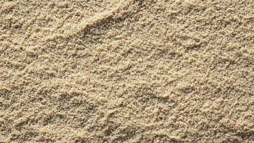 Fine beach sand texture with soft directional ripples.