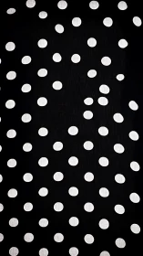 Monochrome polka dot grid on black geometric textile surface.