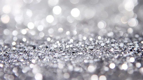 Silver glitter surface with shallow depth of field pattern.