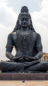 Massive seated Shiva statue in meditative outdoor setting.
