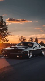 Low-slung black muscle car under glowing sunset sky.