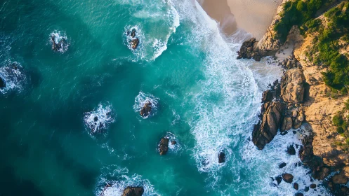 Turquoise surf breaks along rugged golden coastal cliffs.