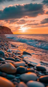 Low-angle coastal sunset with specular pebble reflections.