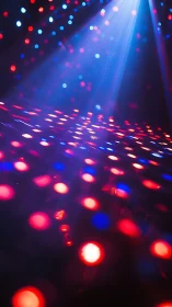 LED dancefloor glows under blue spotlight beams at night.