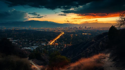 Sunset skyline above city lights viewed from dry hillside.