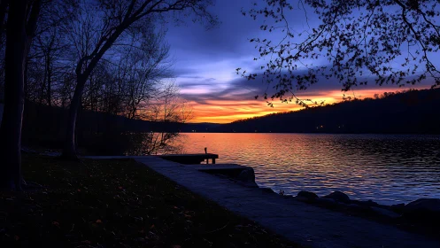Lakeside dock silhouette against blue and orange dusk sky.