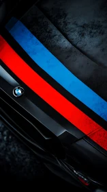 Oblique macro view isolates BMW hood stripes with worn matte finish
