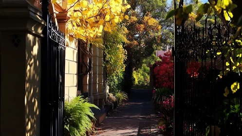 Sunlit garden walkway framed by iron gates and autumn leaves