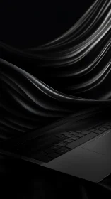 Black laptop keyboard under folded dark fabric drapery.