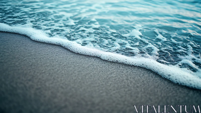 Shoreline wave edge meets wet sand in close foreground focus