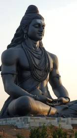 Massive seated Shiva statue in meditative outdoor setting.