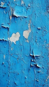 Peeling blue wall becomes abstract seascape of cracked color.