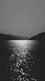 Silvery light shimmers across a tranquil river at dusk.