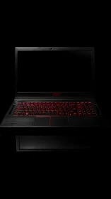 Backlit black laptop with red keyboard on dark background.