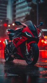 Red sport motorcycle parked on wet city street at night.