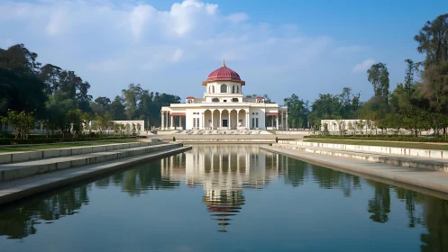 Symmetrical pavilion with axial reflecting pool under clear sky