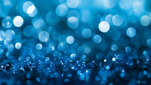 Blue defocused bokeh lights over sparkling surface.