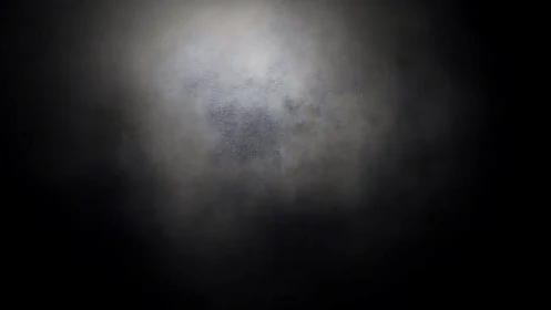 Soft spotlight fades into textured dark vignette field