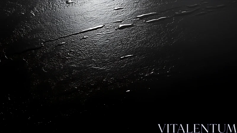 Gleaming streaks across textured black liquid surface.