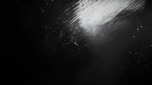 Diagonal light streaks on wet glass with dark negative space.