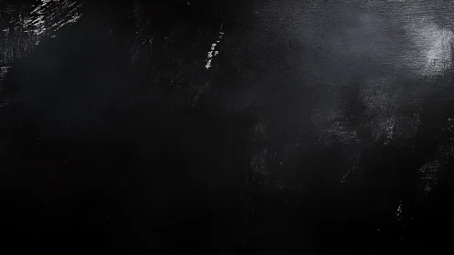 Matte black textured surface with subtle light scuff marks.