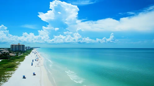 Azure shoreline drifting into infinity beneath sculpted clouds.