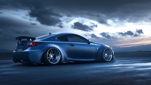Stanced blue sports coupe under dramatic twilight sky.