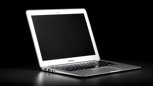 Sleek silver laptop in dramatic low key product lighting.
