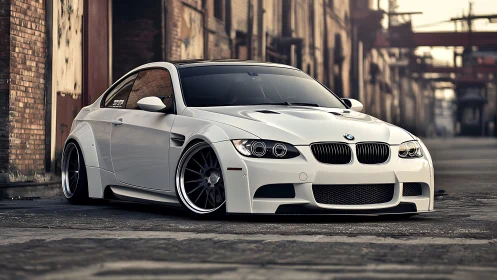 Stanced white BMW coupe with widebody kit in urban alleyway