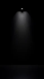 Single ceiling spotlight pierces darkness with soft glow.