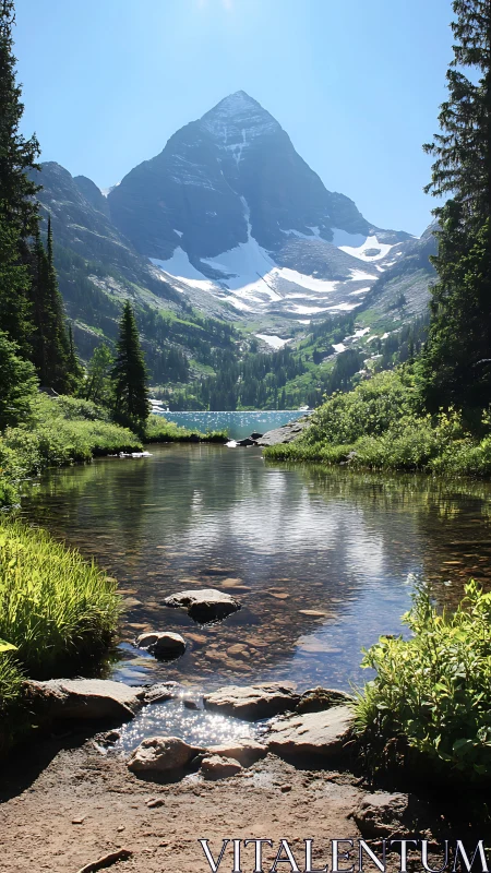 Alpine peak, glacial lake and clear foreground stream under midday sun
