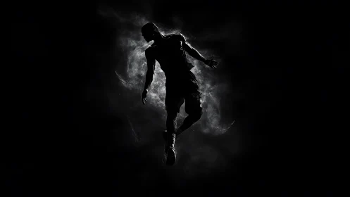Silhouetted basketball athlete suspended in dramatic backlight.