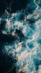 Ocean surface shows turbulent foamy waves in overhead view