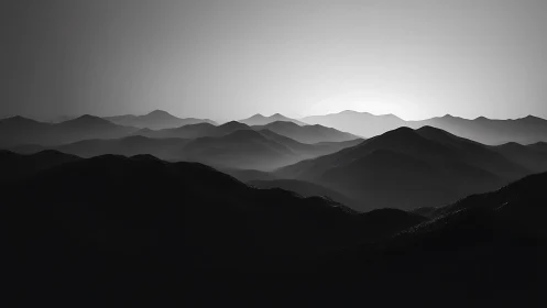 Monochrome mountain ridges in layered atmospheric backlight.