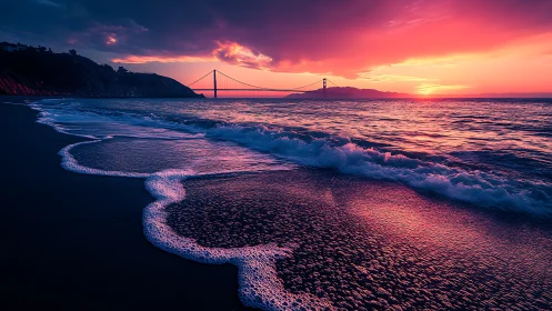 Sunset shoreline with distant suspension bridge view.